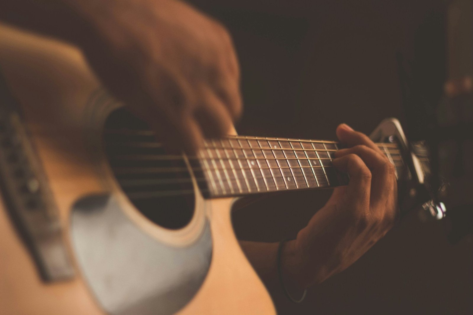 Songwriter mapping out song structure with guitar and notebook in a Dubai recording studio