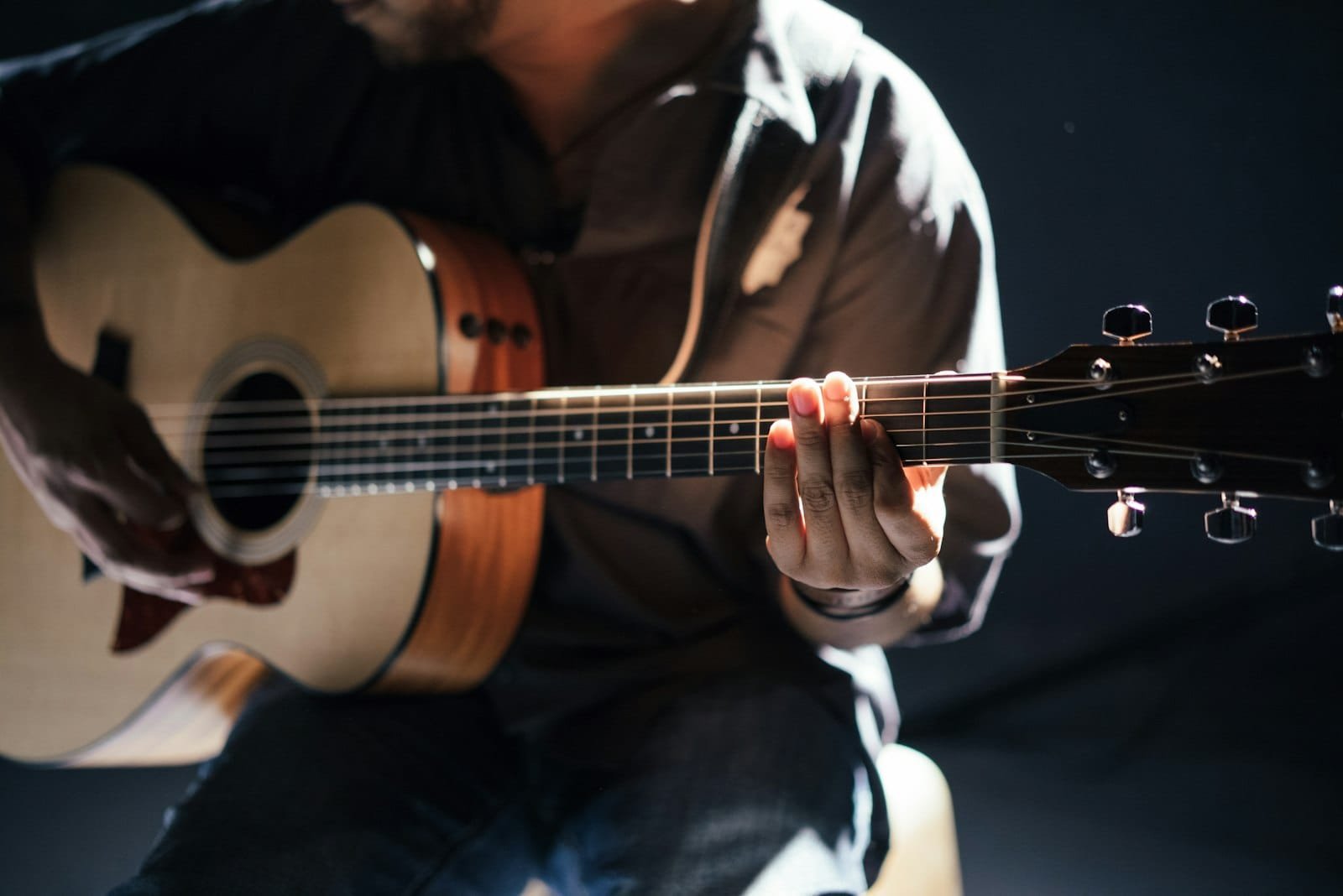 How to write a song — songwriter playing acoustic guitar while writing a song in a Dubai recording studio